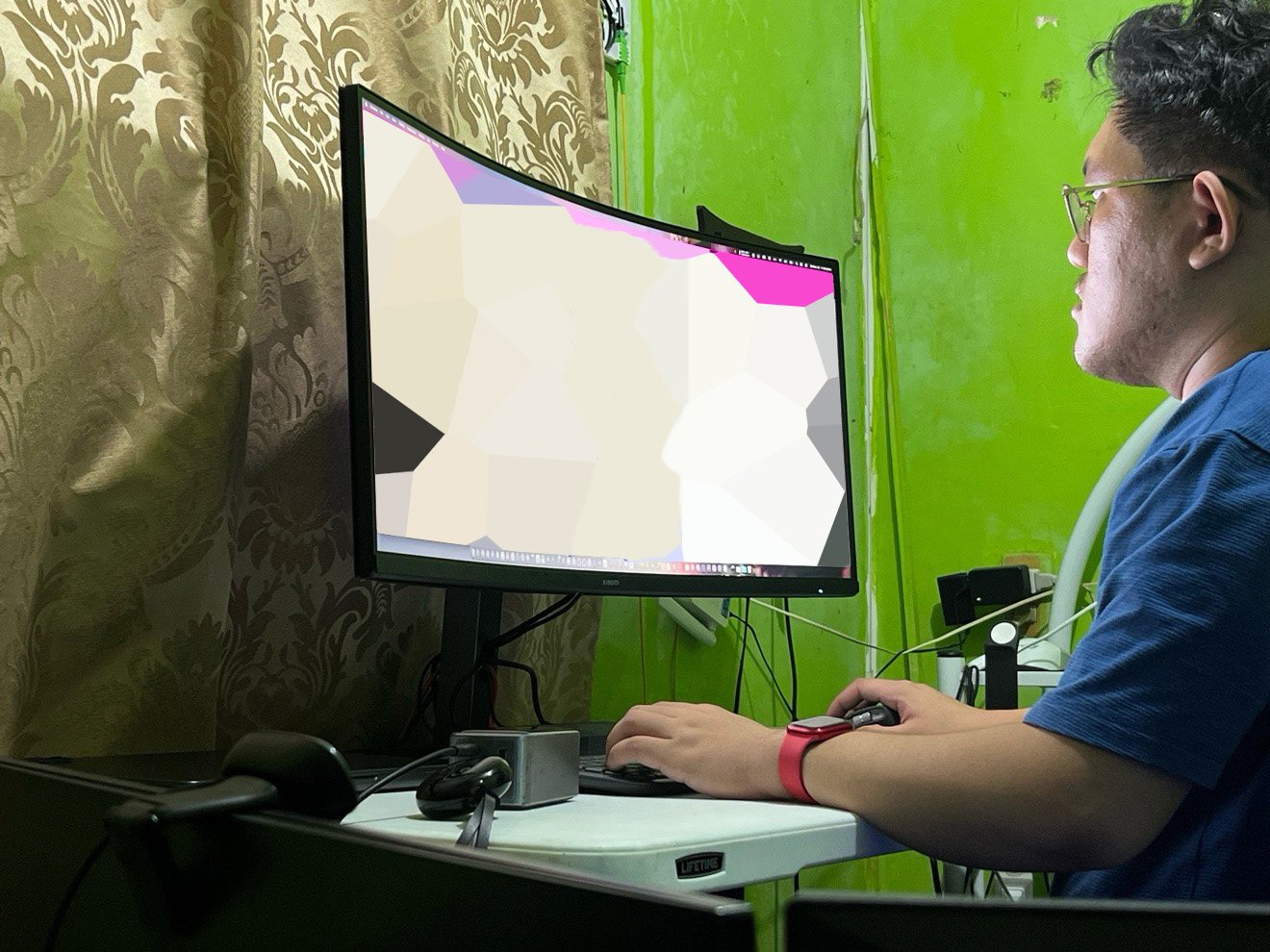 Roel working at a curved monitor at his desk during the remote QA internship